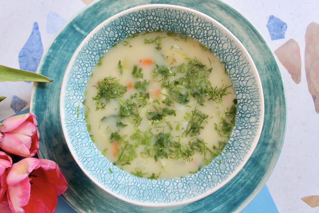 pyszna zupa jarzynowa z ziołami w miseczce na talerzu
