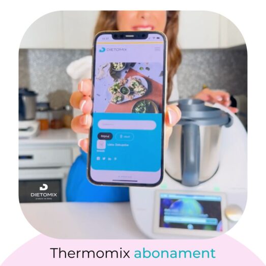 Osoba trzyma smartfon wyświetlający aplikację DIETOMIX z przepisami kulinarnymi na pierwszym planie, z niewyraźnym Thermomixem i jego wyświetlaczem w tle. Na smartfonie otwarta jest strona główna aplikacji z menu i opcjami logowania. Poniżej obrazka znajduje się logo DIETOMIX oraz napis 'Thermomix abonament' wskazujący na dostęp do usług subskrypcyjnych